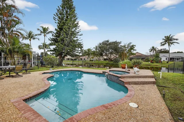 a view of a swimming pool with outdoor seating and plants