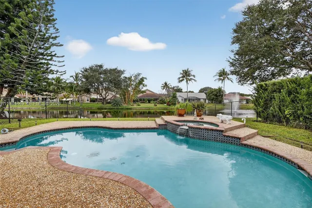 a view of a swimming pool with a yard and a fountain