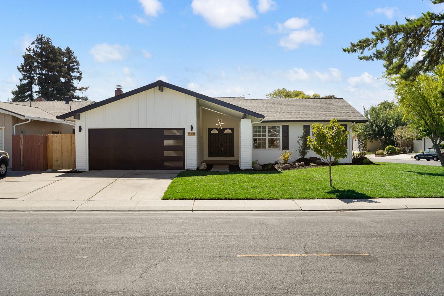 a front view of a house with a garden and garage