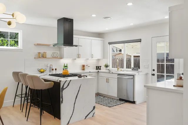 a kitchen with a sink chairs and cabinets