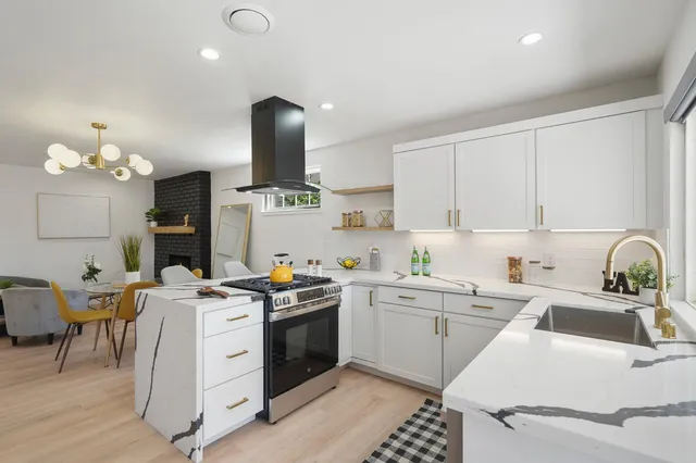a kitchen that has a sink a stove and chair
