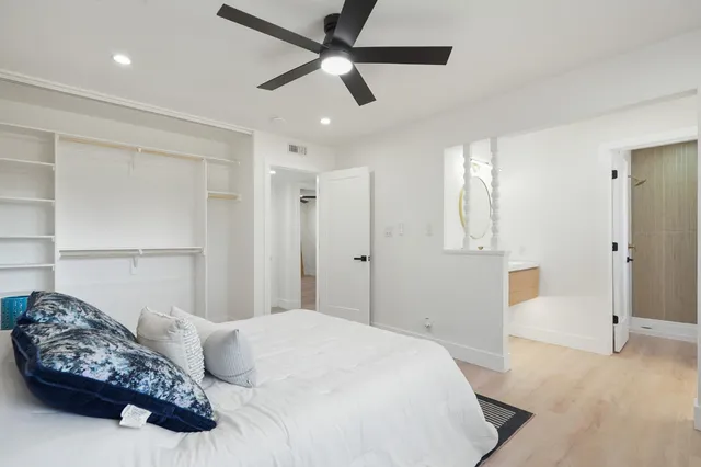 a bedroom with a large bed and a chandelier