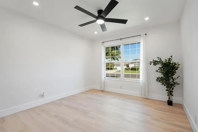 a view of an empty room with a window and a ceiling fan