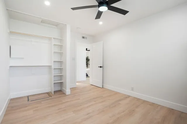 an empty room with closet and windows
