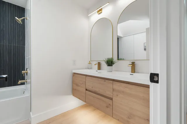 a bathroom with a tub sink and mirror