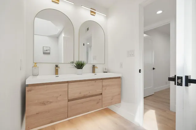 a bathroom with double vanity sink and a mirror