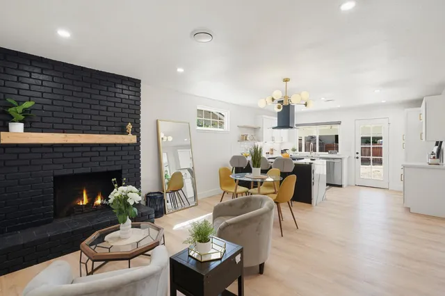 a living room with furniture potted plant fireplace and wooden floor