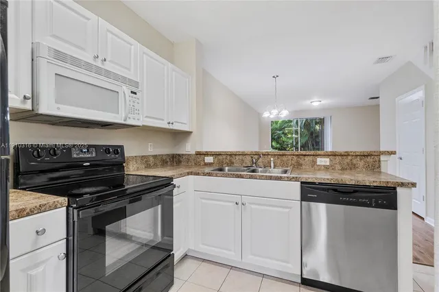 a kitchen with white cabinets and appliances