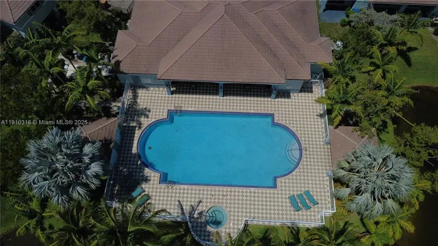 an aerial view of a house with swimming pool and garden space