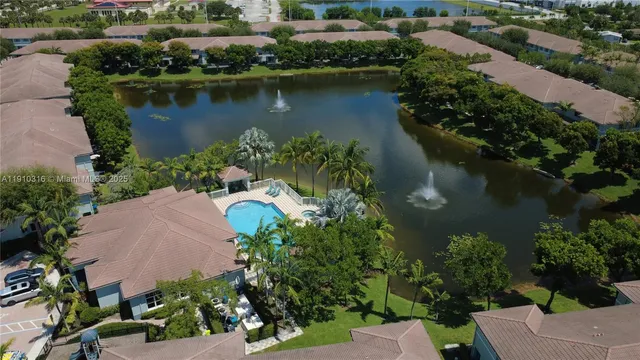 an aerial view of a house with a yard and lake view