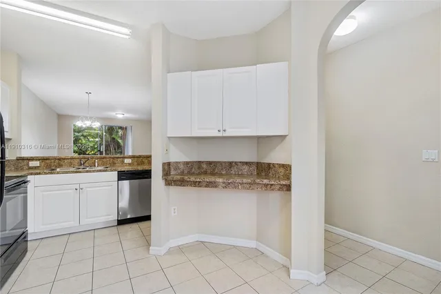 a kitchen with white cabinets and appliances