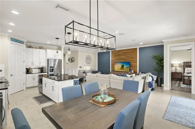 a living room with furniture kitchen view and a chandelier