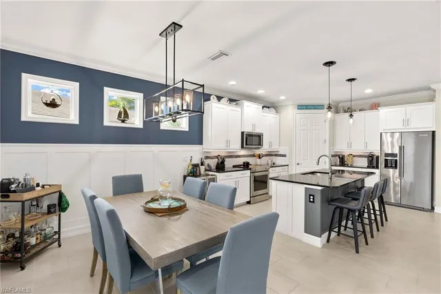 a view of a dining room and livingroom with furniture wooden floor a rug and a chandelier
