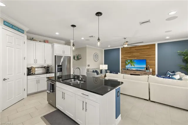 a kitchen with stainless steel appliances a stove a sink a microwave a refrigerator a stove a white table and chairs