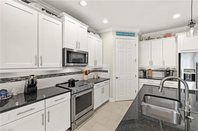 a kitchen with stainless steel appliances granite countertop a stove a sink and a refrigerator