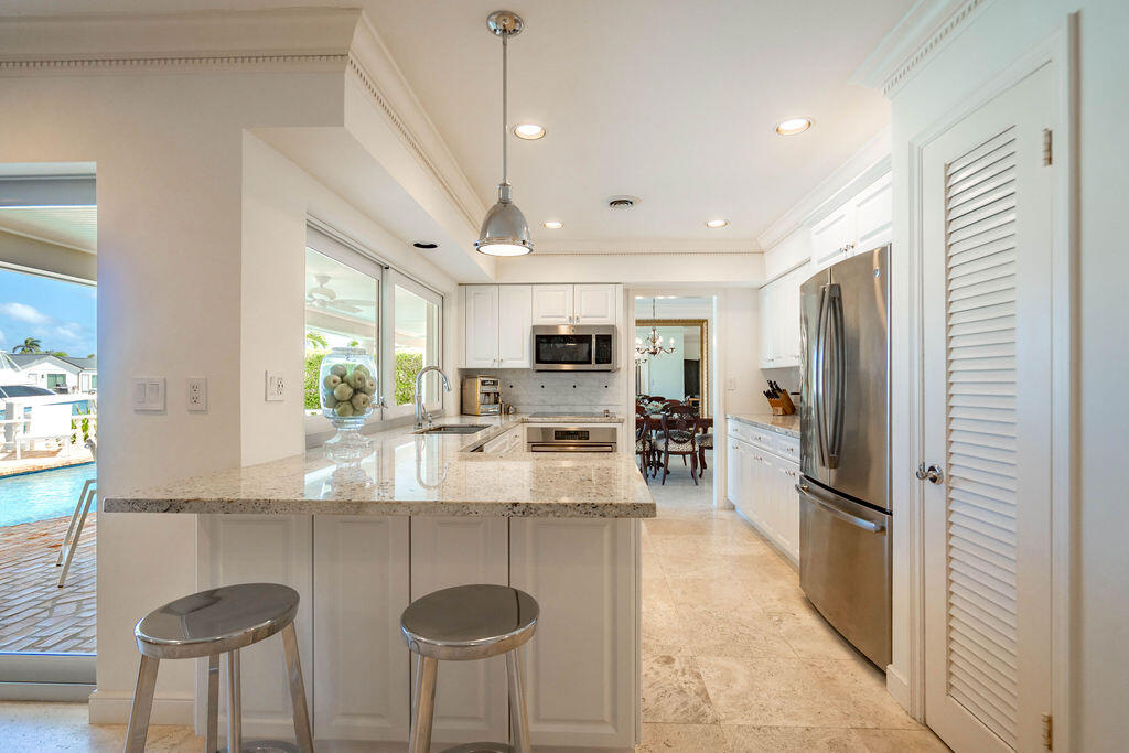 4450 Northeast 24th Terrace Lighthouse Point, FL 33064 - Photo 15 of 47 a large kitchen with kitchen island a large counter top space appliances and cabinets
