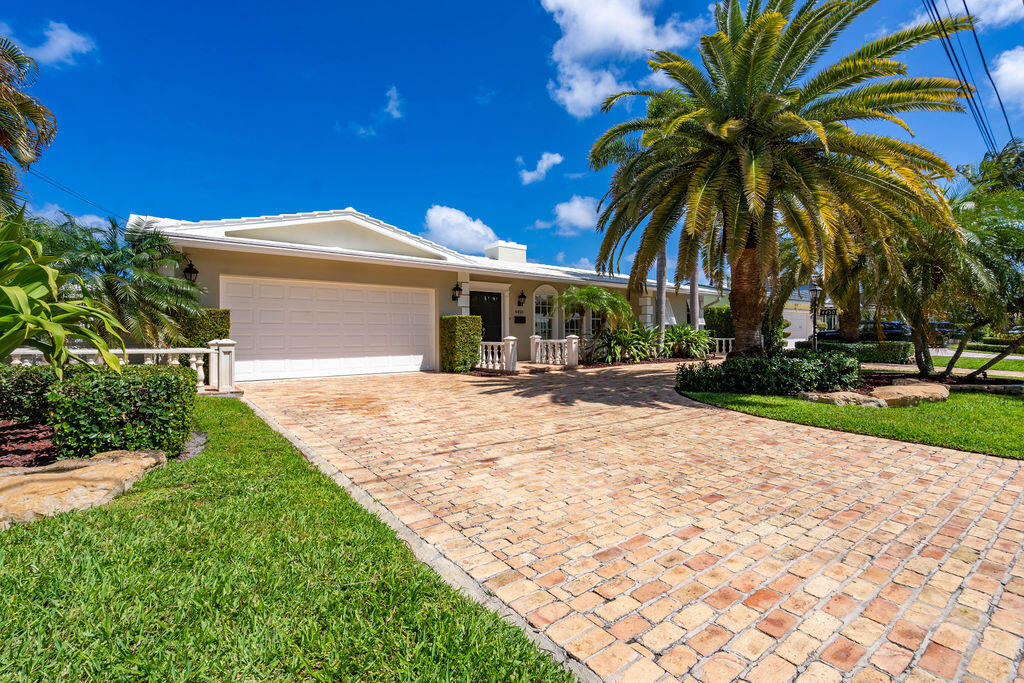 4450 Northeast 24th Terrace Lighthouse Point, FL 33064 - Photo 2 of 47 a front view of house with yard and green space