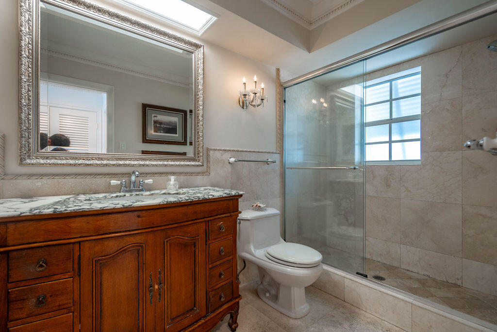 4450 Northeast 24th Terrace Lighthouse Point, FL 33064 - Photo 22 of 47 a bathroom with a granite countertop sink toilet a mirror and shower
