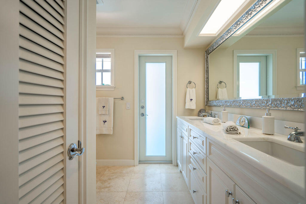 4450 Northeast 24th Terrace Lighthouse Point, FL 33064 - Photo 25 of 47 a bathroom with a double vanity sink and a mirror