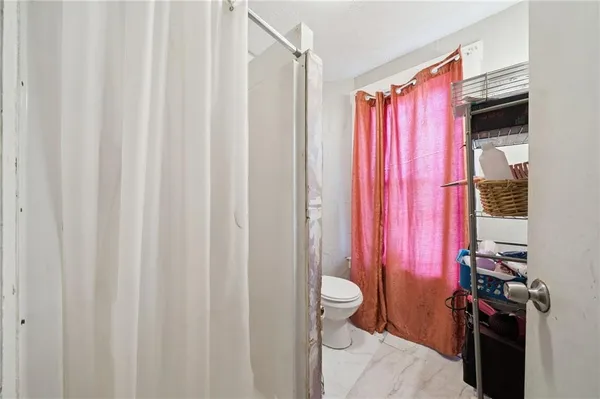 a bathroom with a toilet a sink and a shower curtain