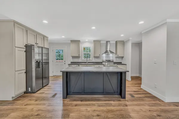 a kitchen with stainless steel appliances granite countertop a refrigerator and a sink