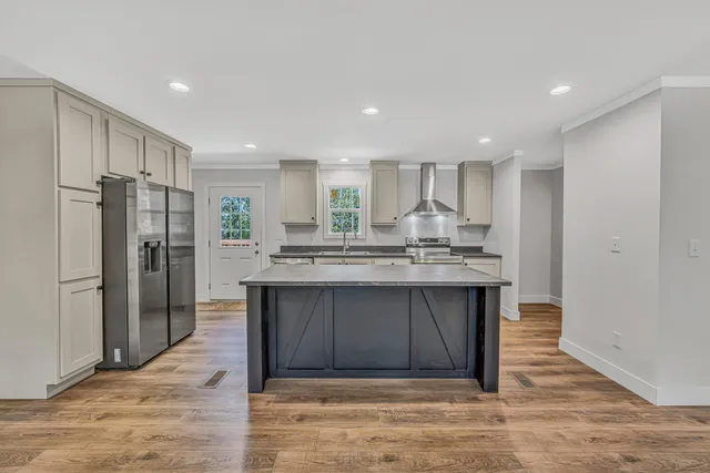 a kitchen with stainless steel appliances granite countertop a refrigerator and a sink