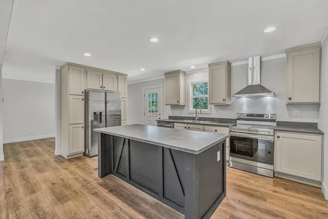 a kitchen with stainless steel appliances granite countertop a sink stove and refrigerator