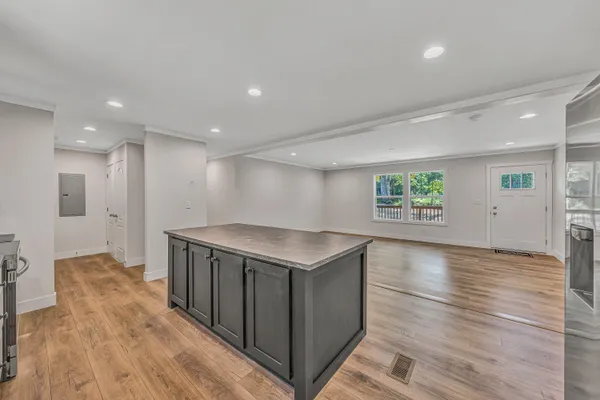a kitchen with a stove and a wooden floor