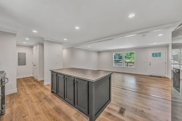 a kitchen with a stove and a wooden floor