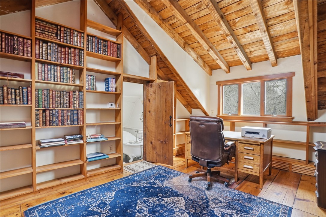 186 Arcadia Road Hopkinton, RI 02832 - Photo 18 of 27 Bedroom with bathroom, also serving as a lovely office, features built-in bookshelves and windows offering nature and Wood River views.
