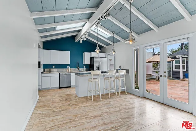a view of a kitchen with stainless steel appliances kitchen island granite countertop a refrigerator and microwave