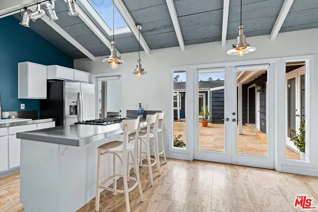 a kitchen with stainless steel appliances a refrigerator a sink and wooden floors