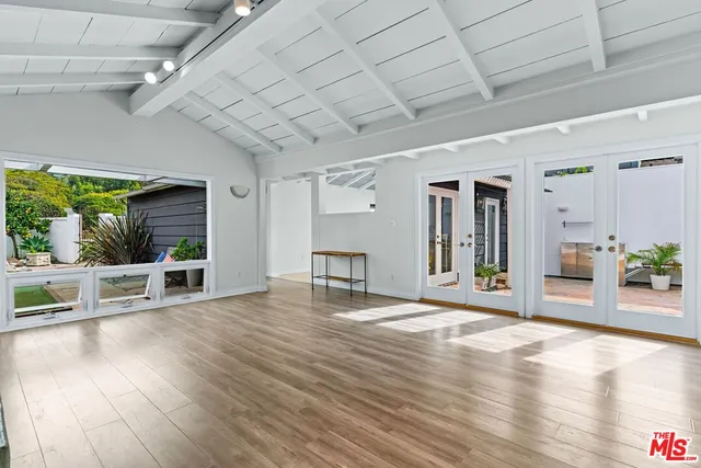 a view of an empty room with wooden floor fireplace and a window