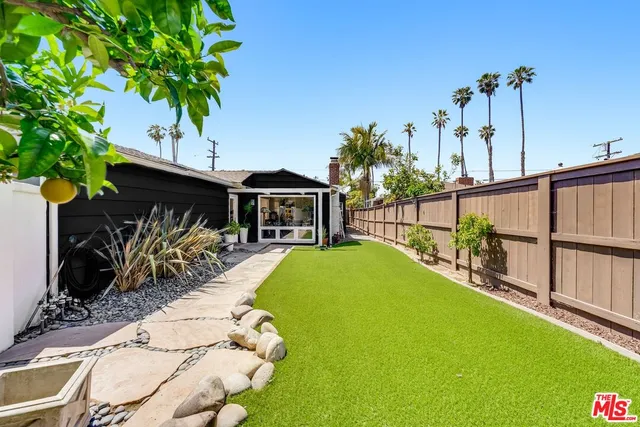 a view of a house with backyard and sitting area