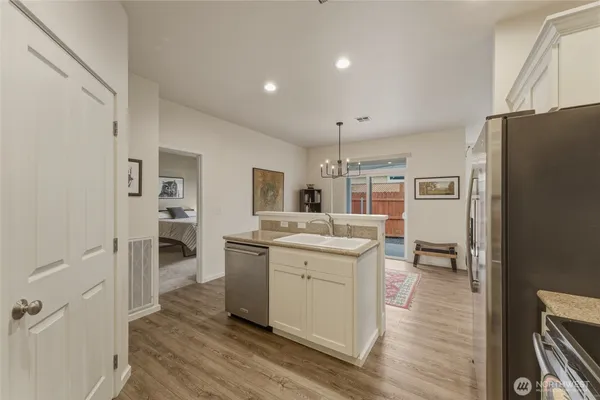 a view of living room kitchen with stainless steel appliances granite countertop furniture and a refrigerator