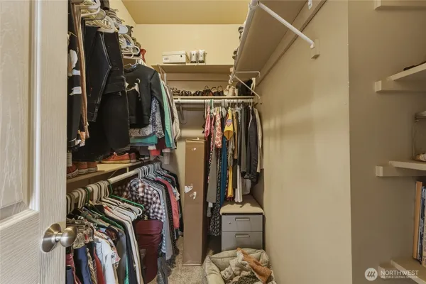 a view of walk in closet with clothes and shoes