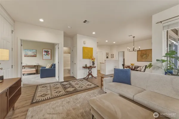 a living room with furniture a rug and kitchen view