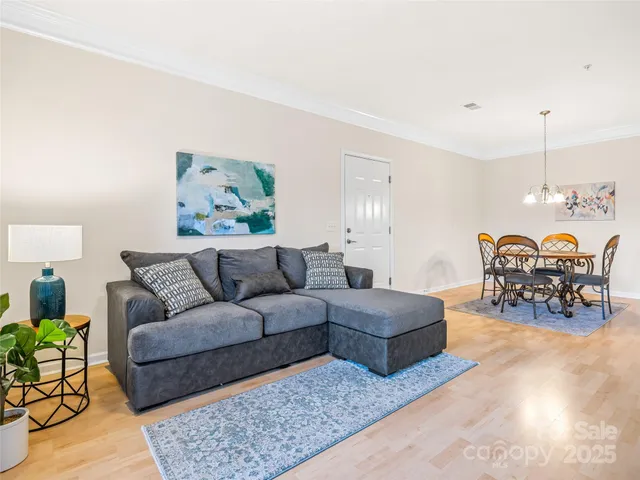 a living room with furniture and a dining table with kitchen view