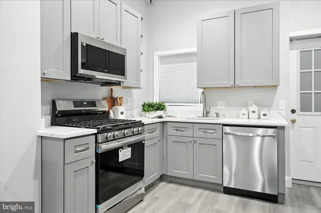 a kitchen with white cabinets and stainless steel appliances