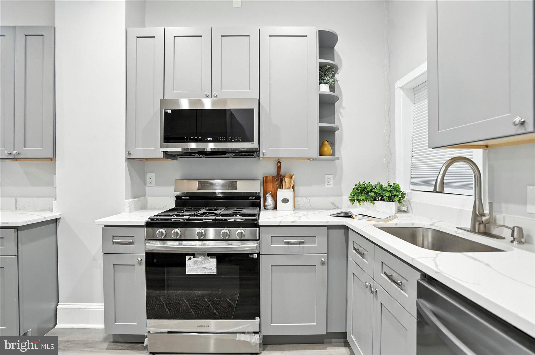 1628 East Biddle Street Baltimore, MD 21213 - Photo 12 of 35 a kitchen with granite countertop a stove and a sink