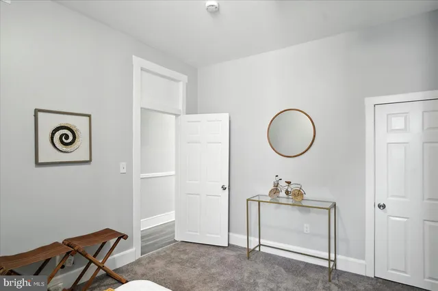 a living room with a mirror and a wooden floor