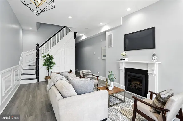 a living room with furniture a flat screen tv and a fireplace