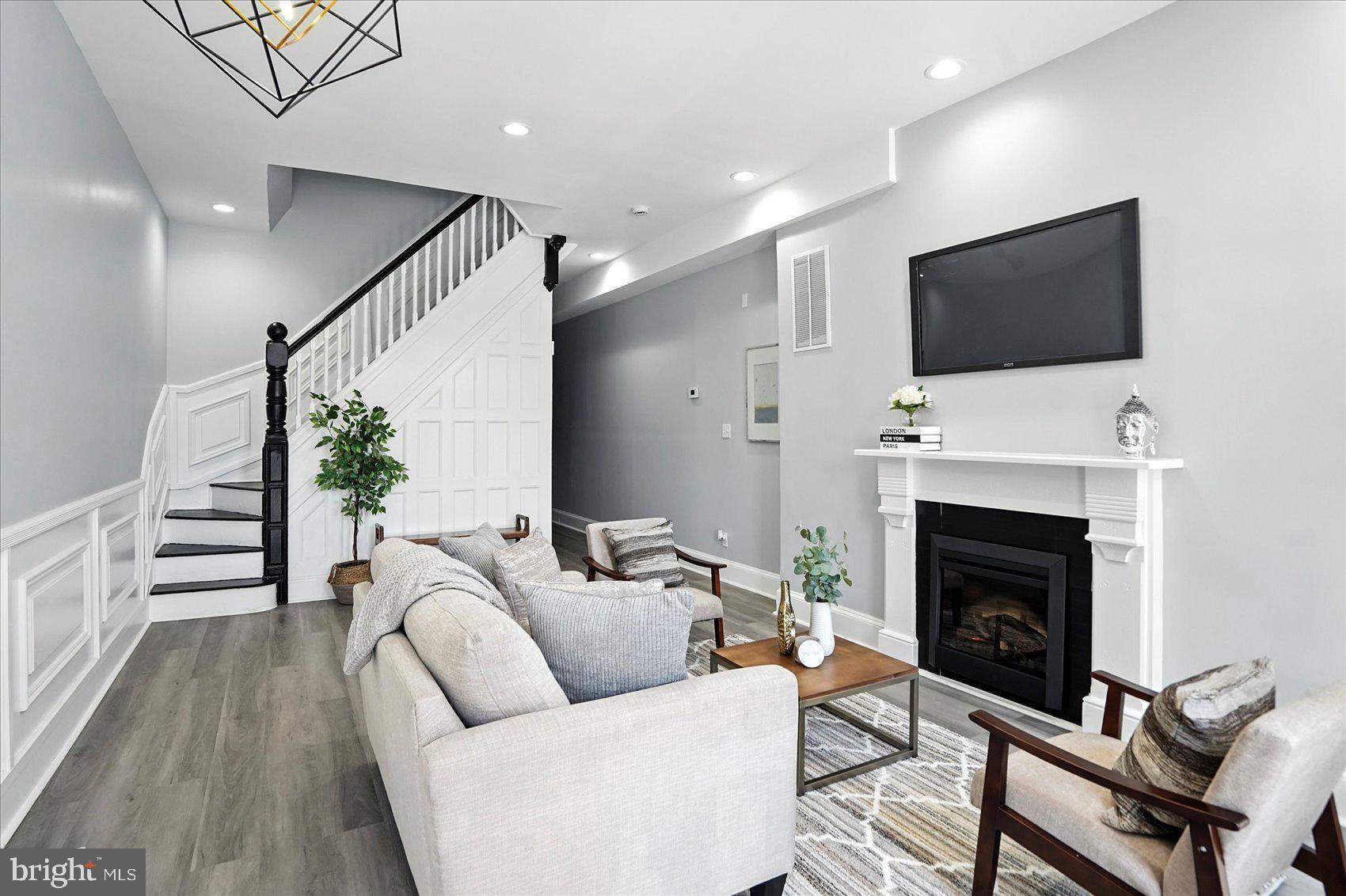 1628 East Biddle Street Baltimore, MD 21213 - Photo 2 of 35 a living room with furniture a flat screen tv and a fireplace
