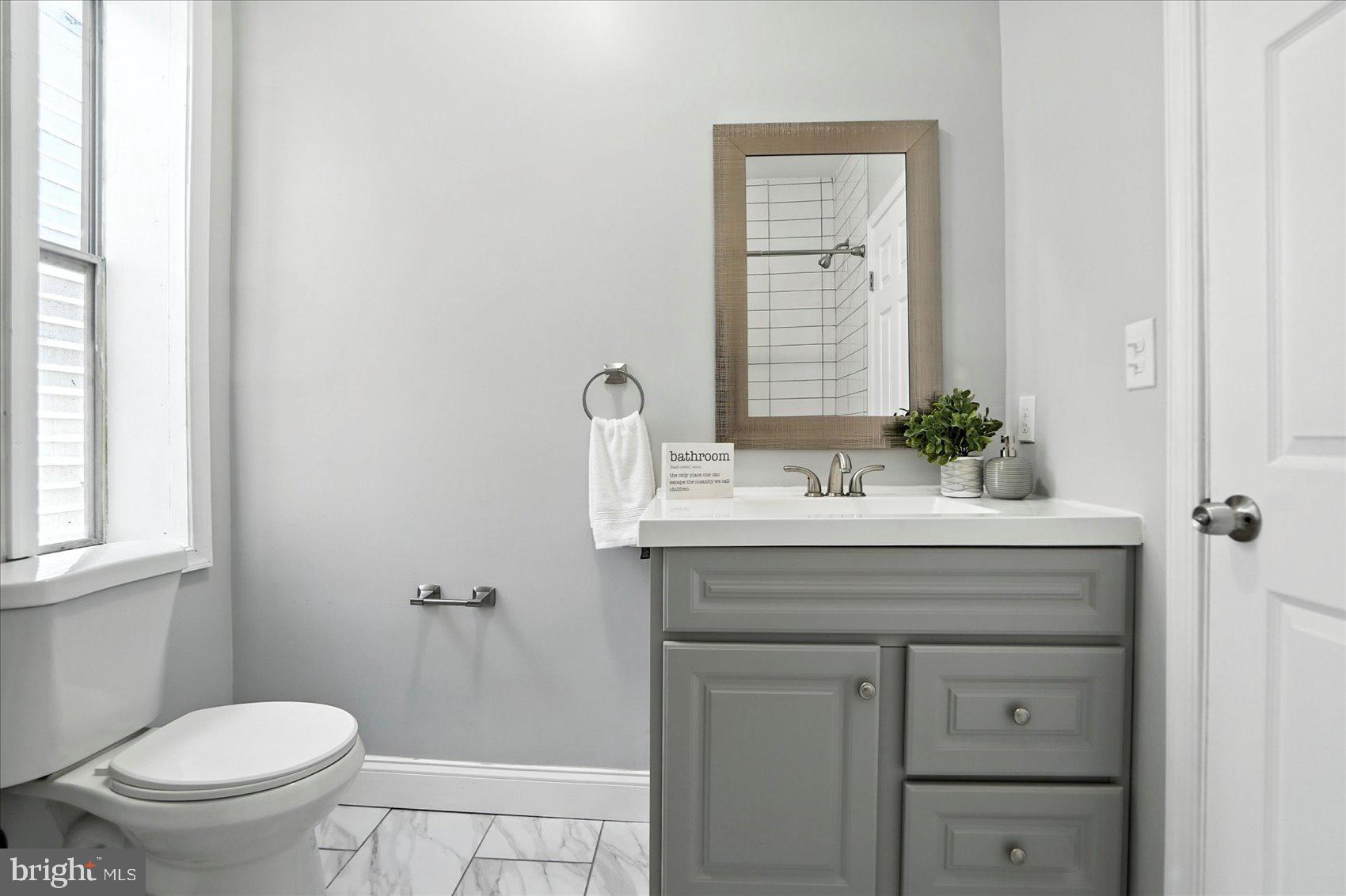 1628 East Biddle Street Baltimore, MD 21213 - Photo 21 of 35 a bathroom with a sink a toilet and mirror
