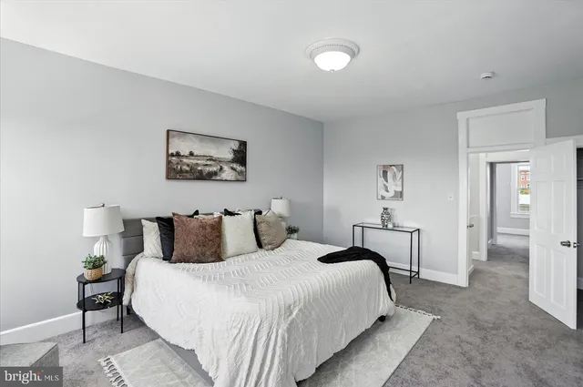 a bedroom with a bed and a painting on the wall