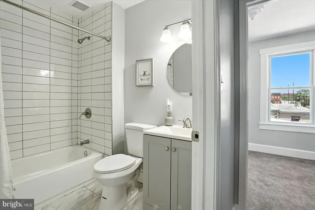 a bathroom with a toilet sink vanity tub and shower