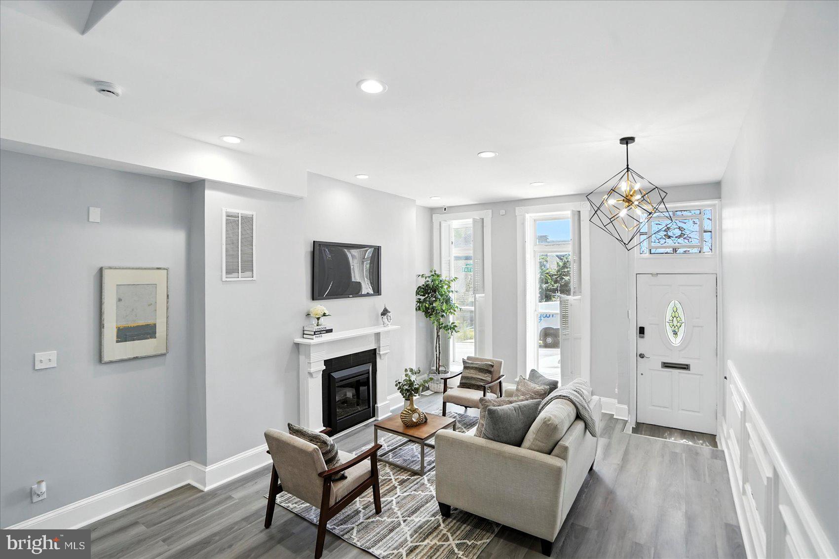 1628 East Biddle Street Baltimore, MD 21213 - Photo 4 of 35 a living room with furniture a fireplace and a flat screen tv