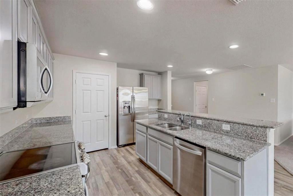 1103 Brazoria Road Forney, TX 75126 - Photo 7 of 25 a kitchen with stainless steel appliances granite countertop a sink stove and refrigerator
