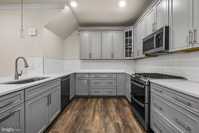 a kitchen with stainless steel appliances granite countertop white cabinets and stove top oven