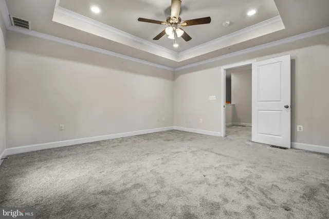 an empty room with chandelier fan